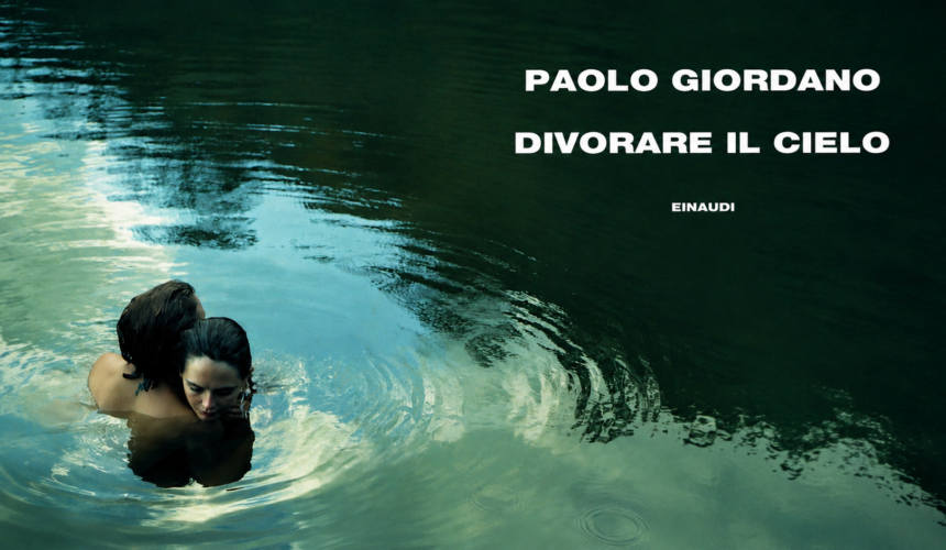 Due persone abbracciate immerse nell’acqua scura e riflettente, con il titolo “Divorare il cielo” di Paolo Giordano in bianco nella parte superiore destra dell’immagine.