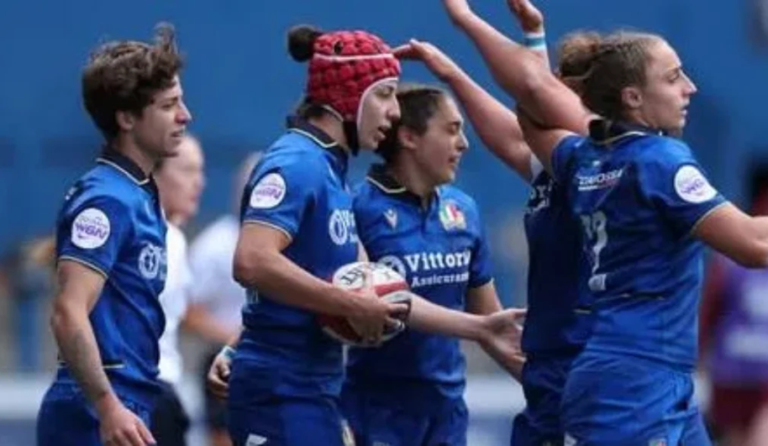 Giocatrici della nazionale italiana femminile di rugby in maglia azzurra durante una partita, con una atleta che tiene il pallone in mano.