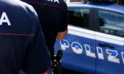 Due agenti della Polizia di Stato vicino a una volante blu durante un servizio di controllo e sicurezza urbana.